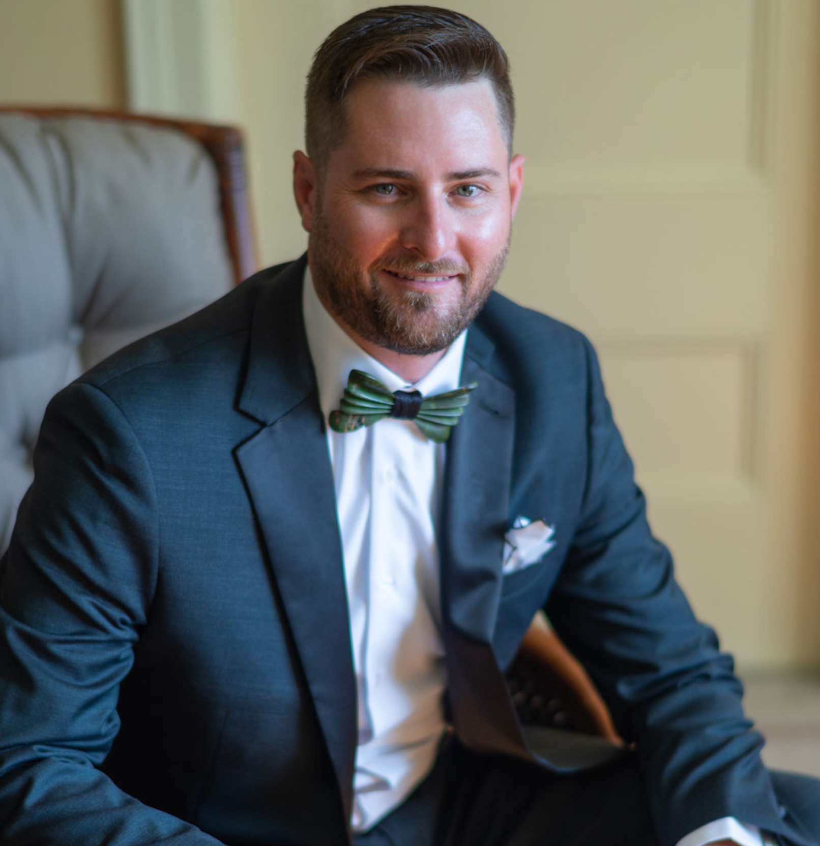 Jamie Nall sitting in a suit and bowtie